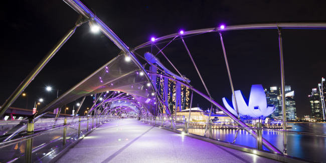 Helix Bridge and the Marina Bay Sands illuminated at night.